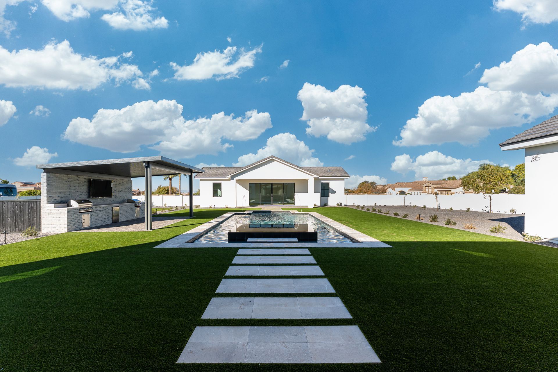 There is a swimming pool in the middle of the backyard.