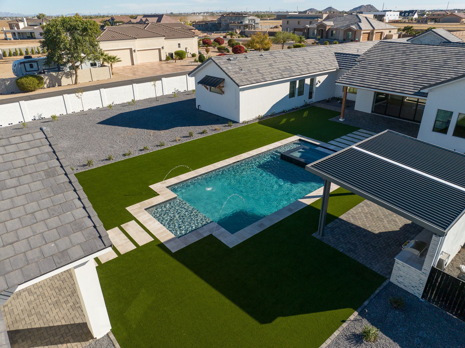 An aerial view of a house with a large swimming pool in the backyard.