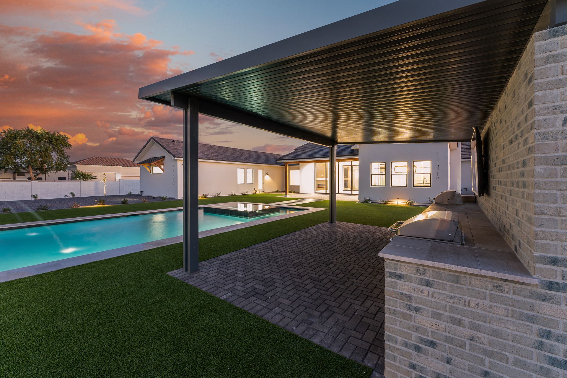 There is a large swimming pool in the backyard of a house.