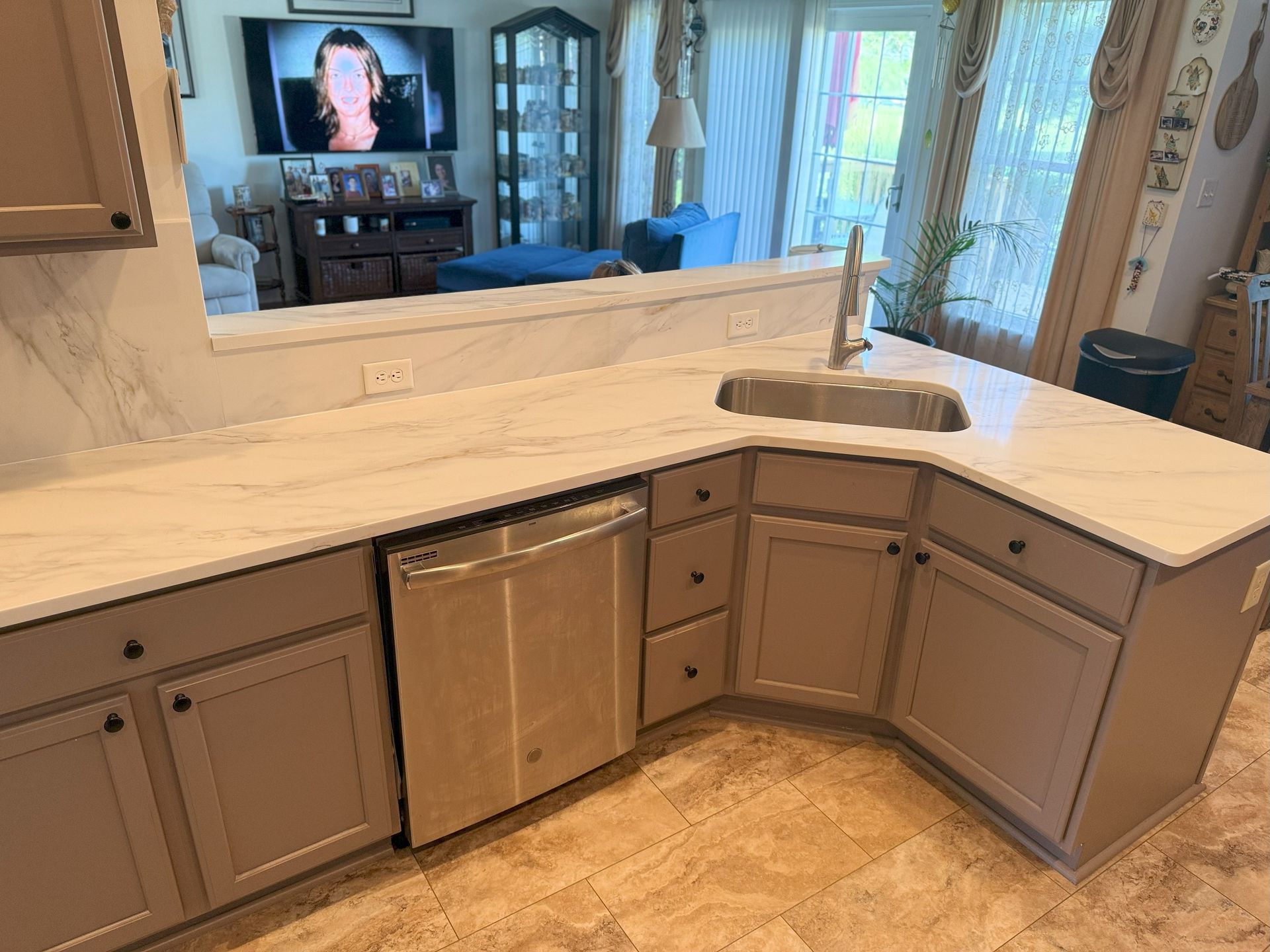 Kitchen with gray cabinets, white countertops, and stainless steel appliances.
