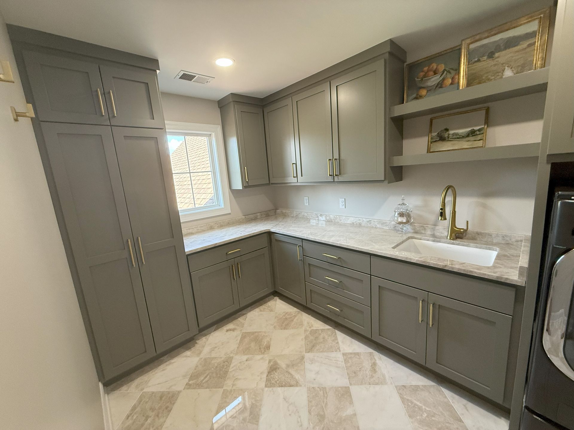 Gray laundry room with cabinets, countertops, sink, and tiled floor.