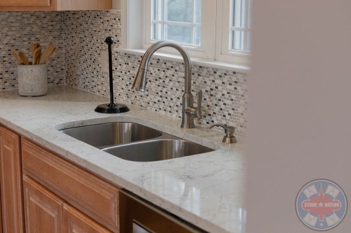 A kitchen with a stainless steel sink and a faucet.