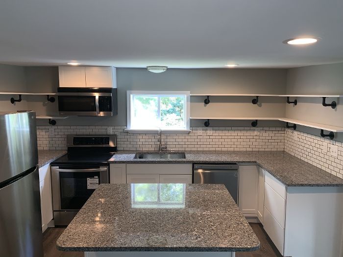 A kitchen with granite counter tops , stainless steel appliances , and a large island.