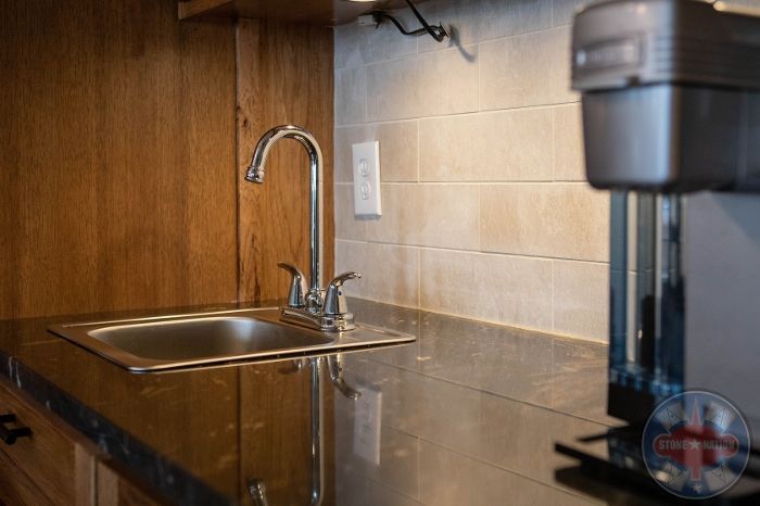 A kitchen counter with a sink and a coffee maker.