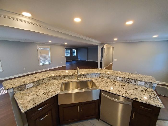 A kitchen with granite counter tops and a stainless steel sink.