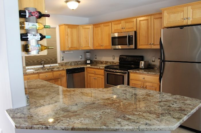 A kitchen with granite counter tops and stainless steel appliances