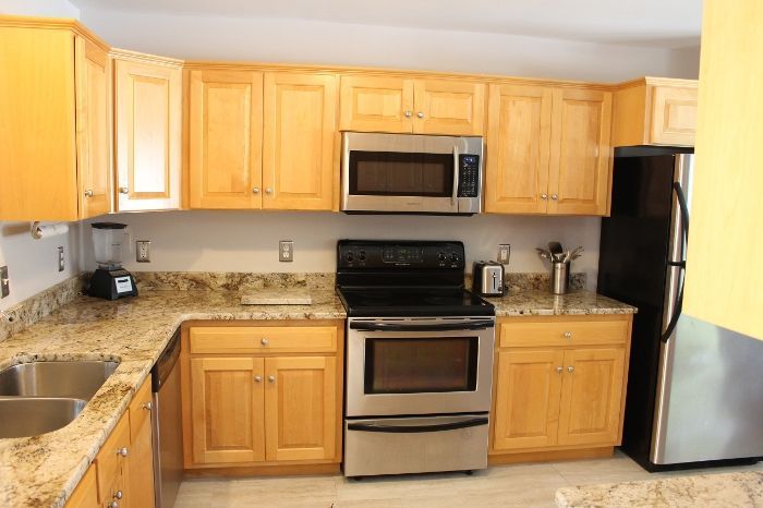 A kitchen with stainless steel appliances and wooden cabinets