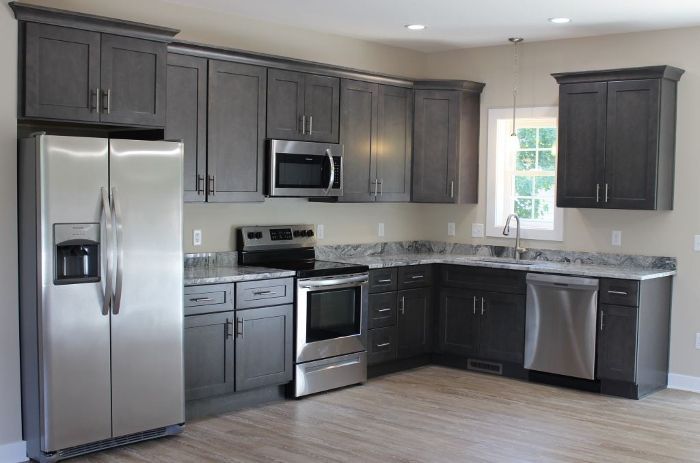 A kitchen with gray cabinets and stainless steel appliances