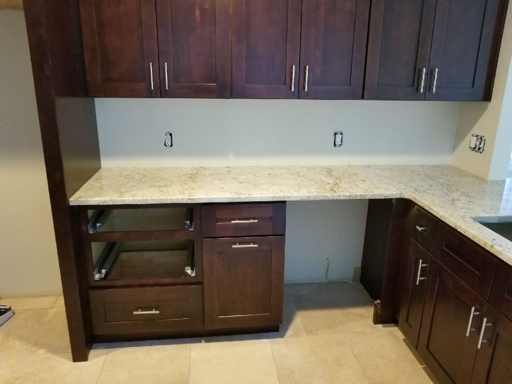 A kitchen with wooden cabinets and granite counter tops