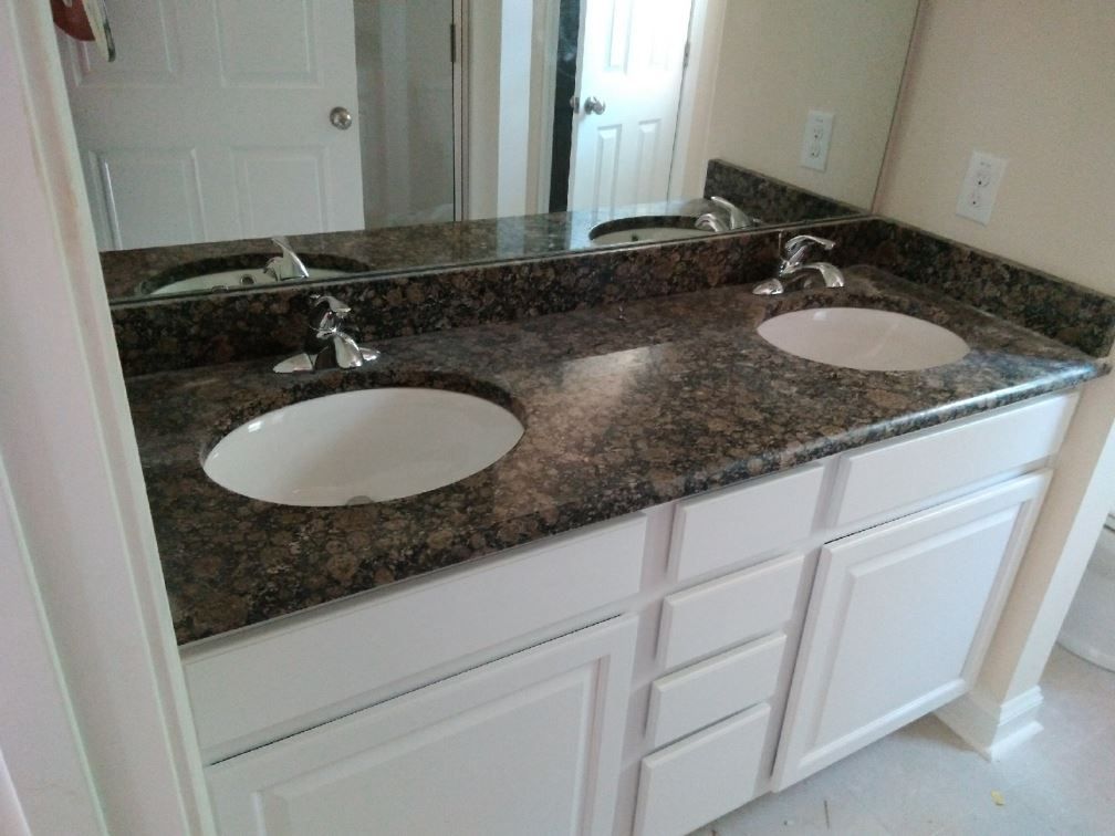 A bathroom with two sinks and a mirror.