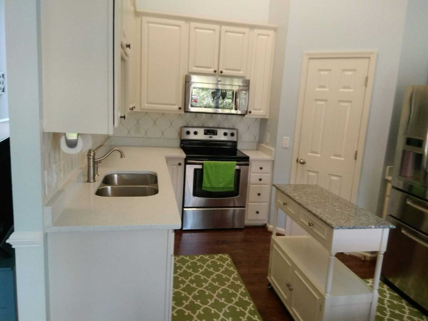 A kitchen with white cabinets and stainless steel appliances