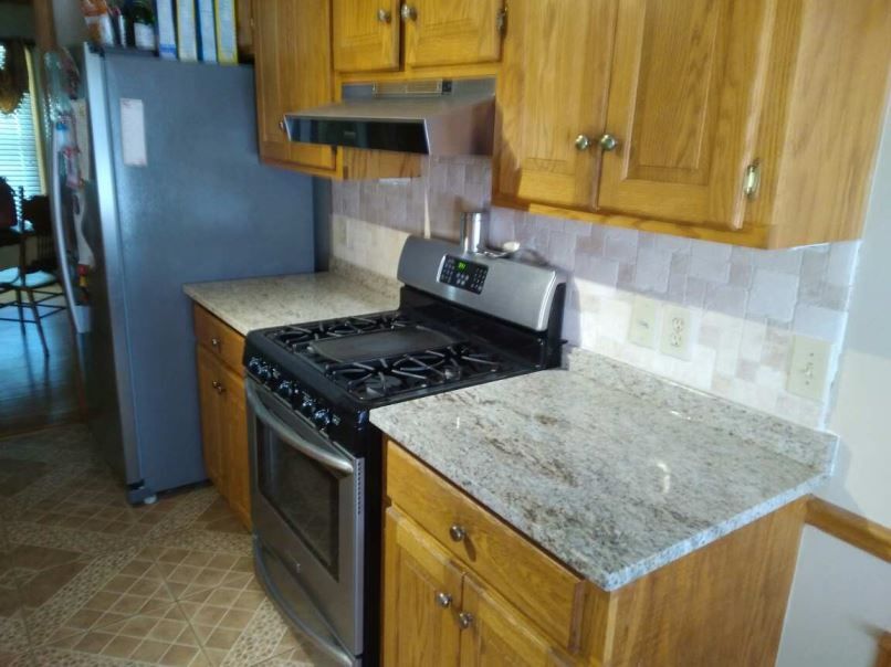 A kitchen with a stove top oven and a refrigerator