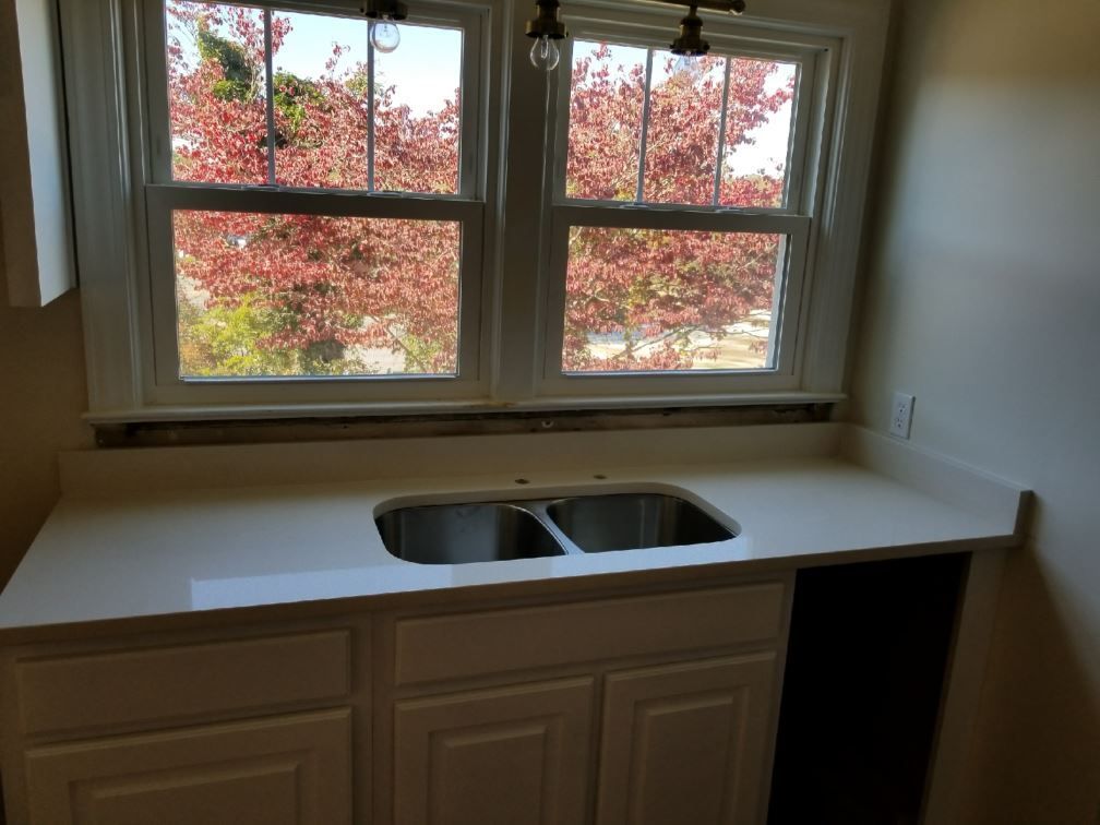 A kitchen counter with a sink and a window