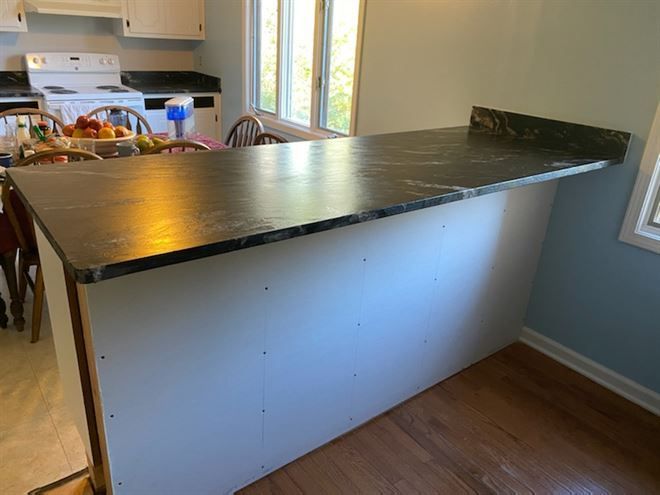 A kitchen with a black counter top and a white stove.