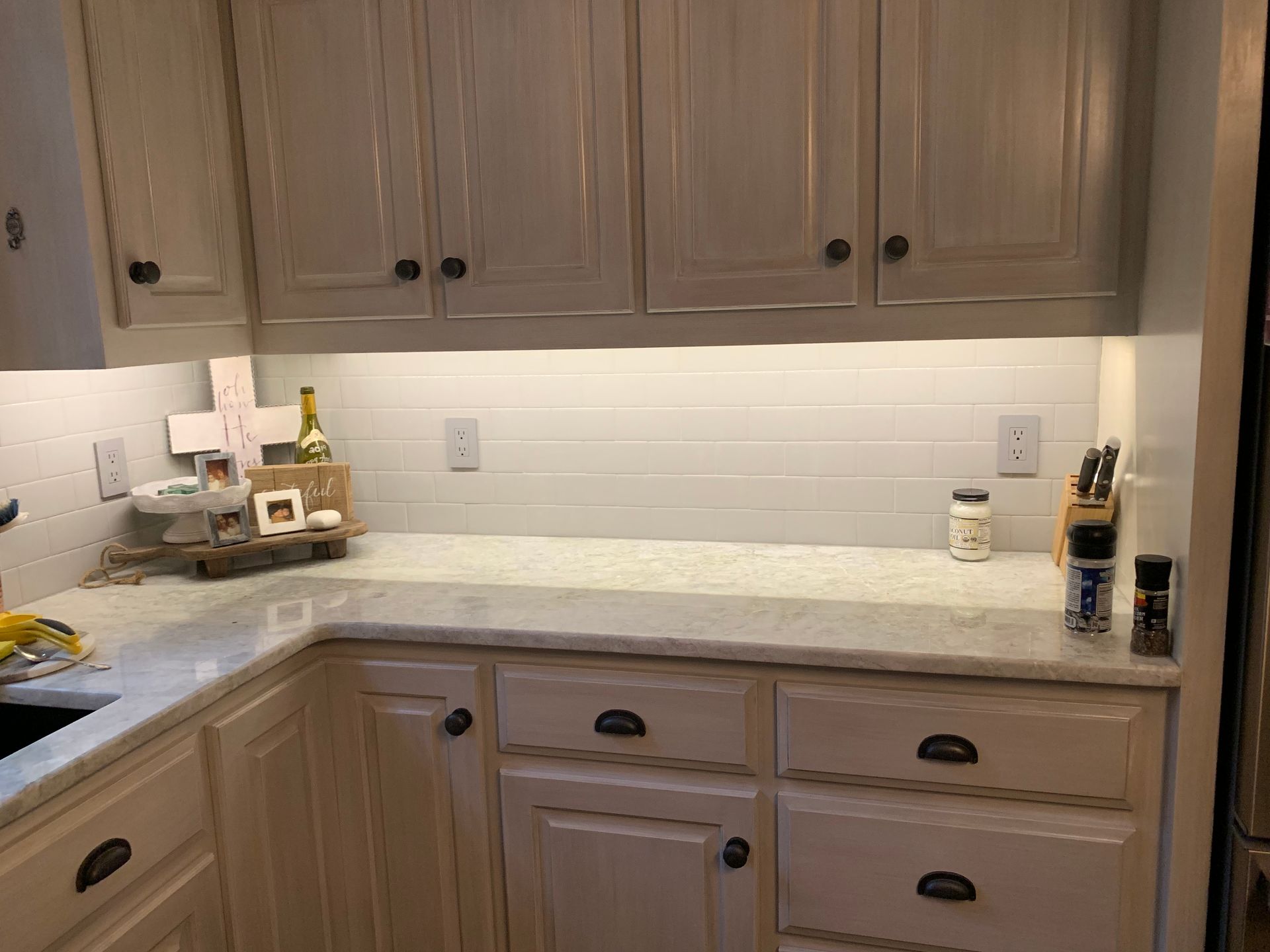 A kitchen with white cabinets and white counter tops.