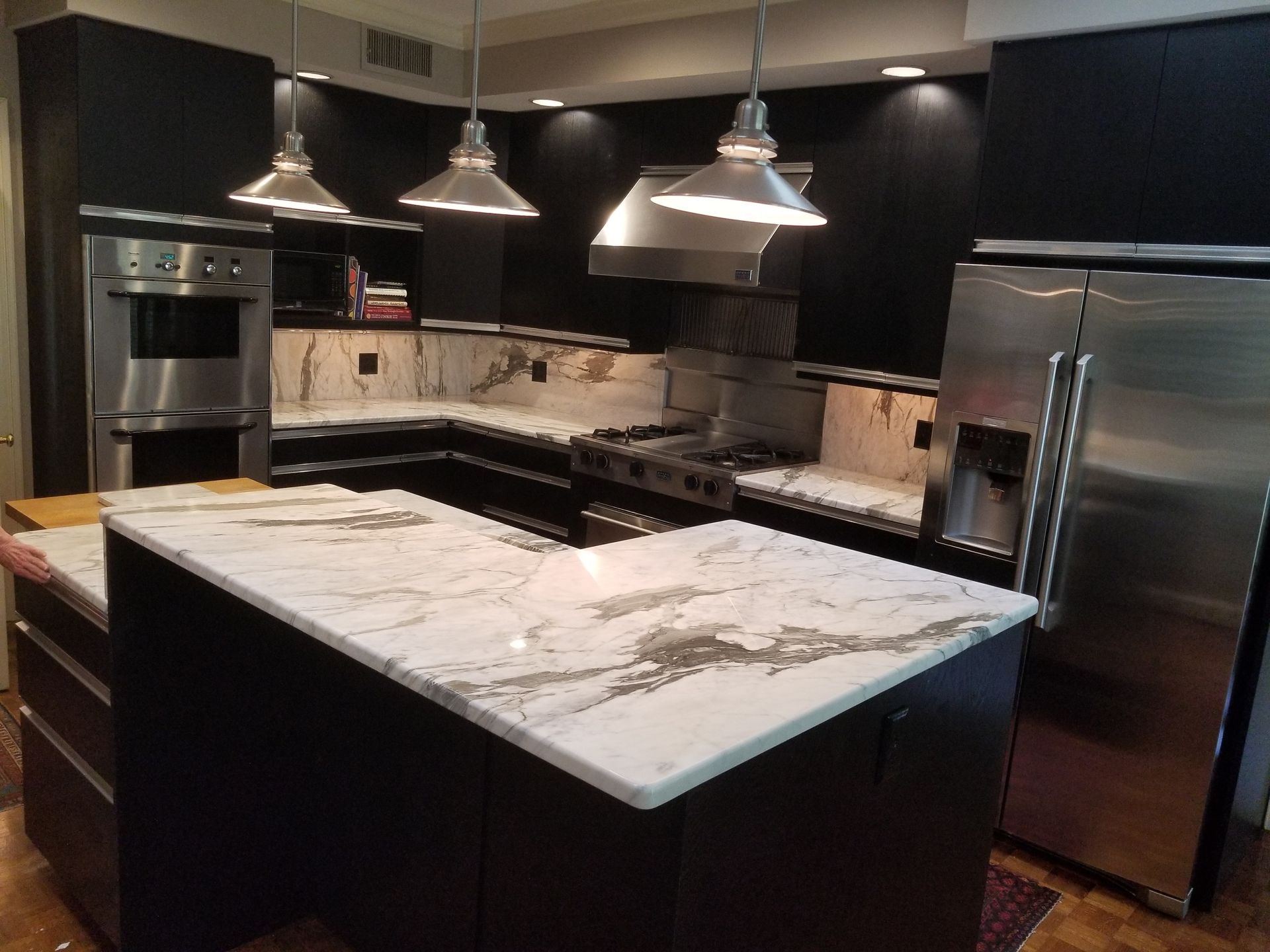 A kitchen with stainless steel appliances and marble counter tops