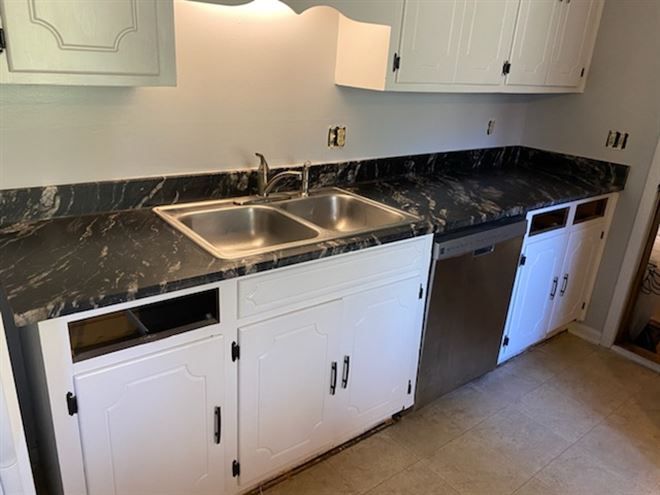 A kitchen with two sinks and a stainless steel dishwasher
