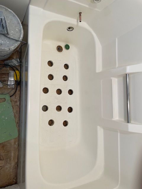 A white bathtub with holes in it
