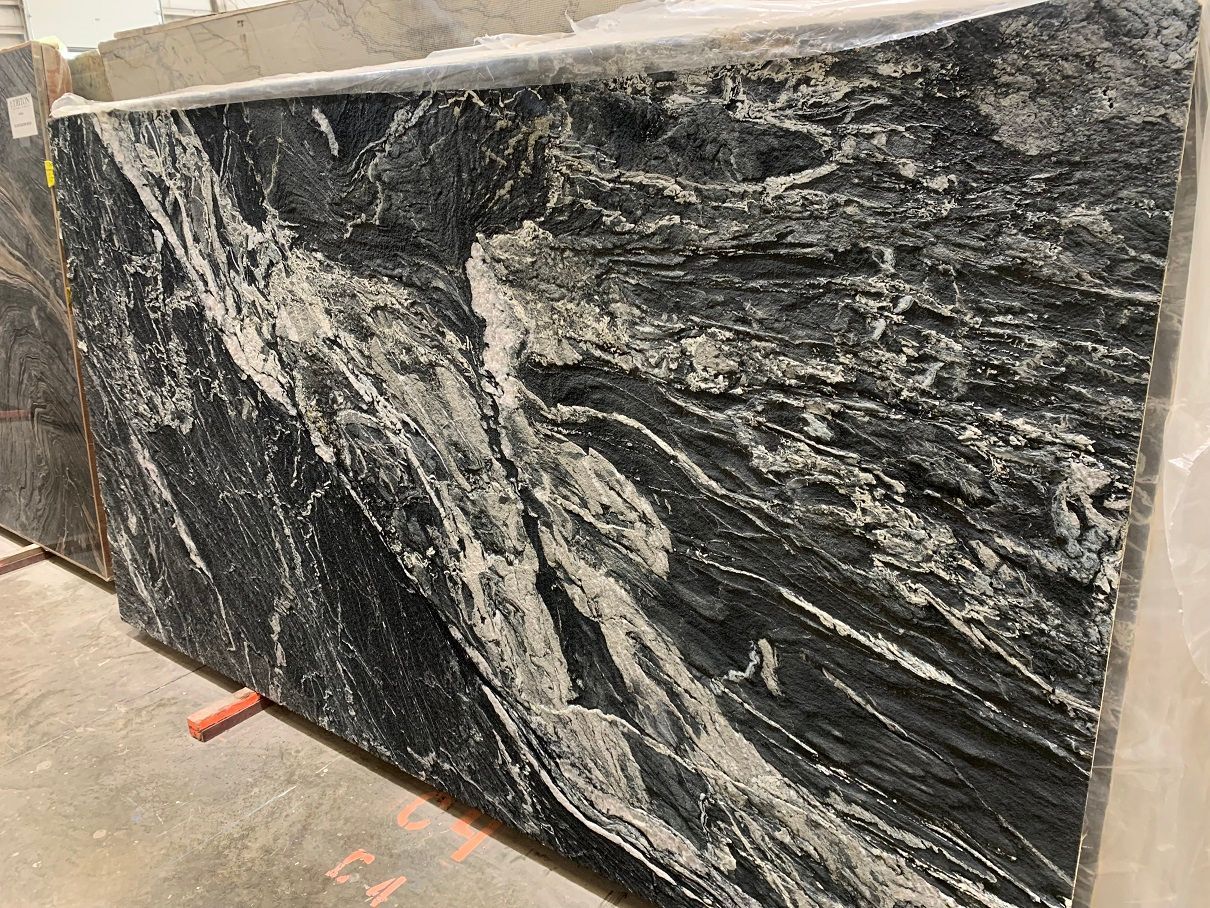 A black and white granite slab is sitting on the ground.