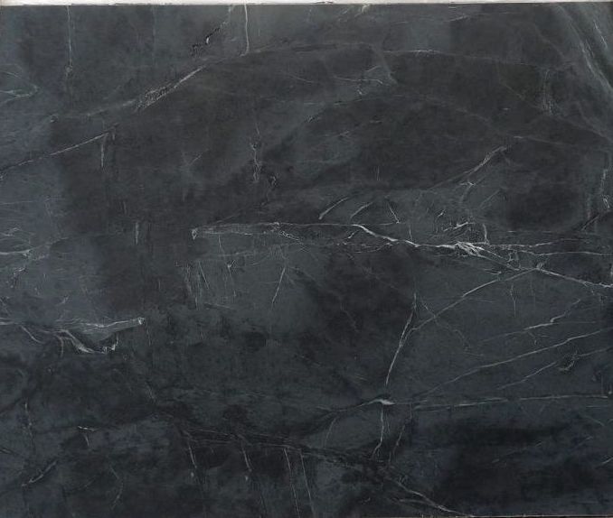 A close up of a black marble tile with a white border.