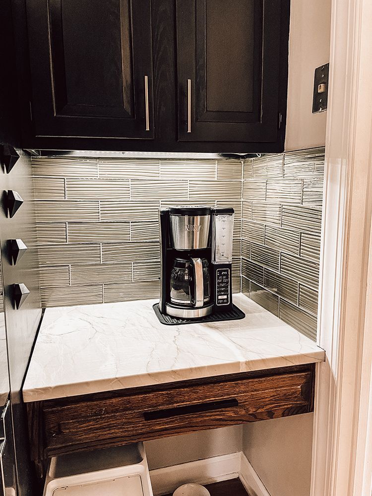 A coffee maker is sitting on top of a counter in a kitchen.