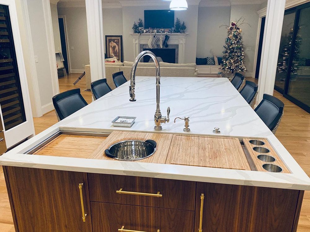 A kitchen island with a sink and a christmas tree in the background.