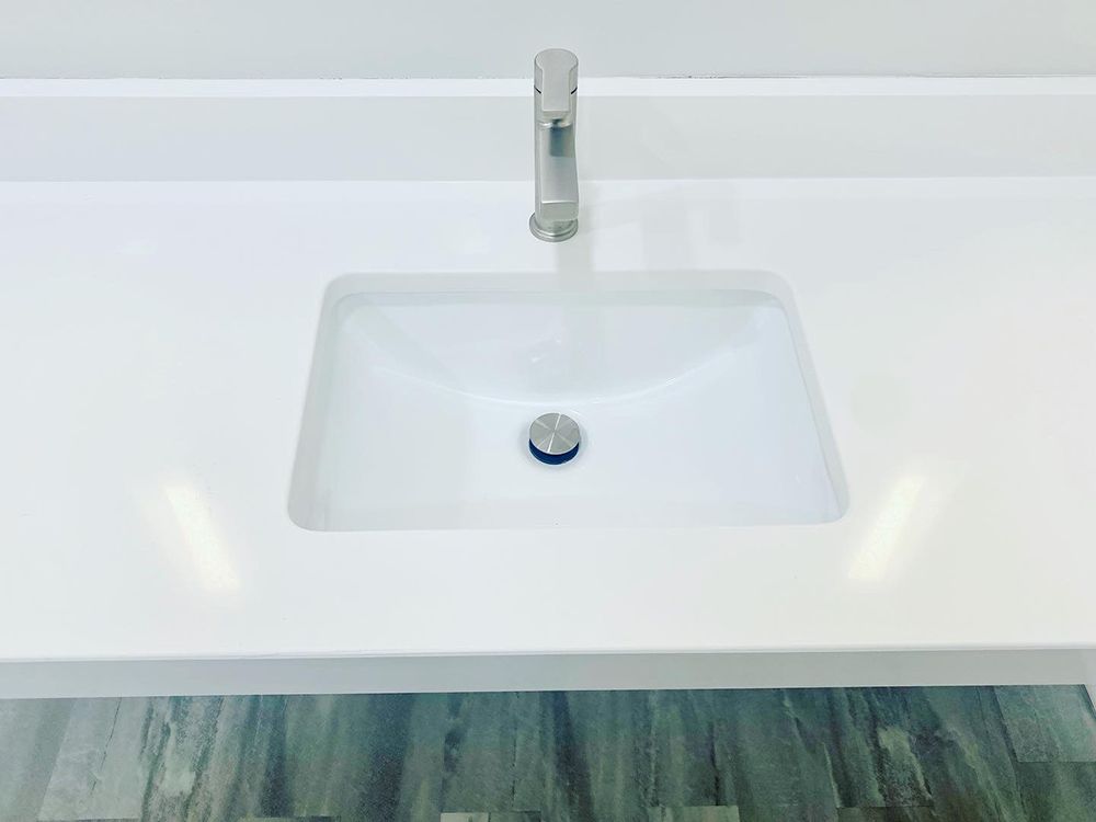 A bathroom sink with a faucet on a white counter top.