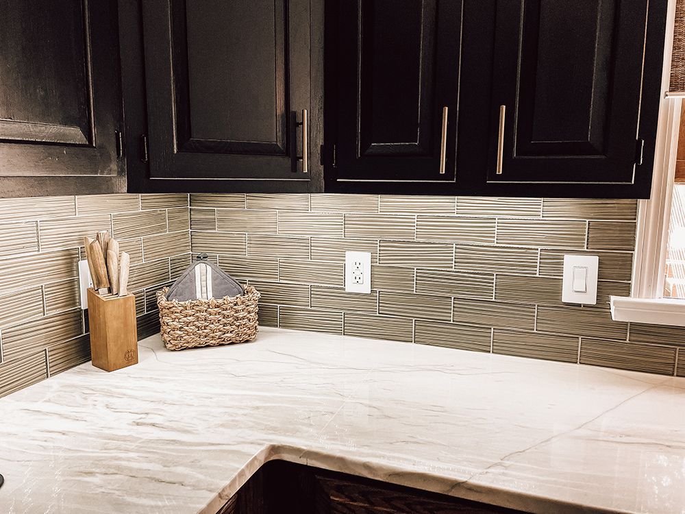 A kitchen with black cabinets and a white counter top.