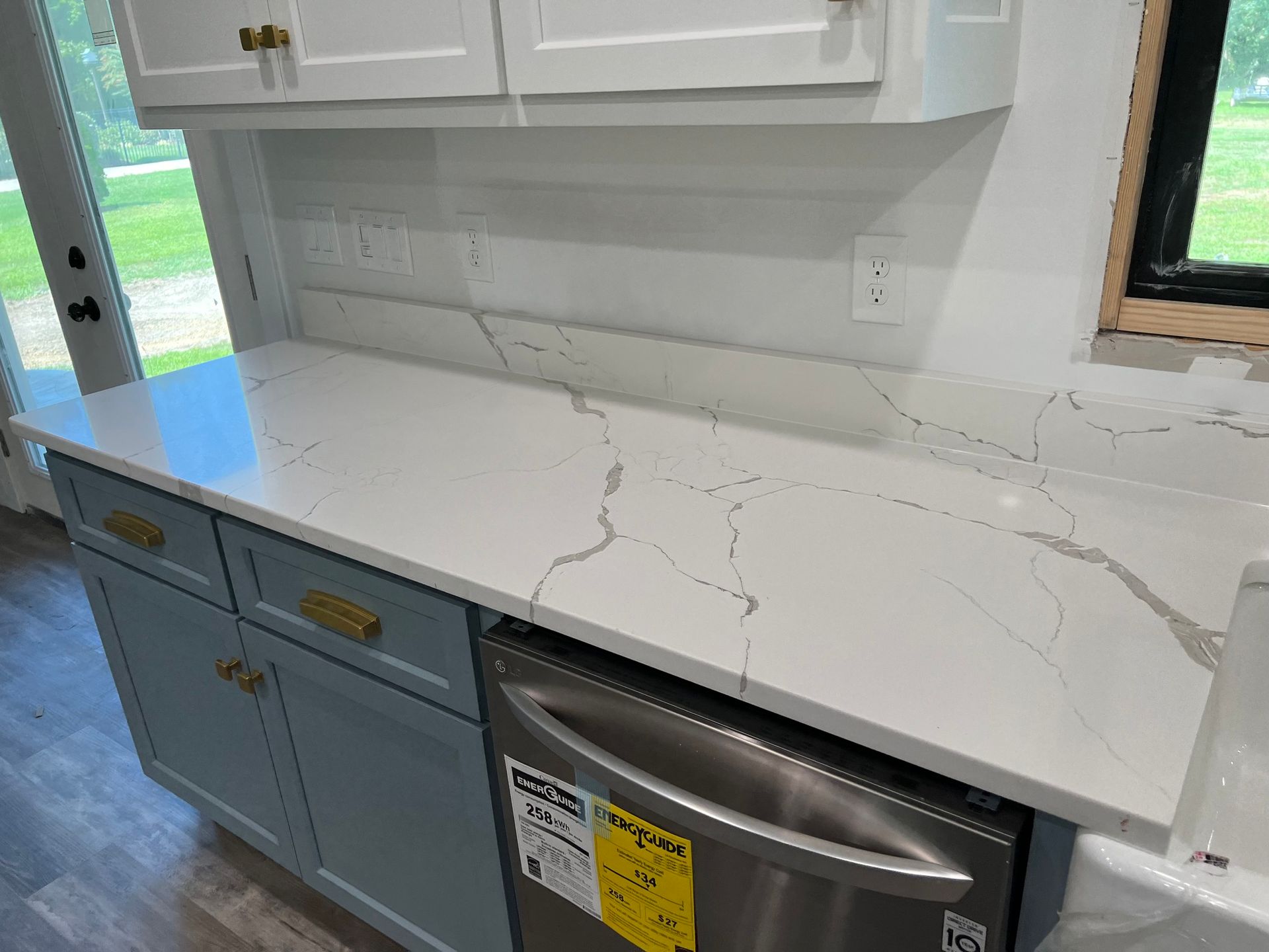 A kitchen with white cabinets and a stainless steel dishwasher.