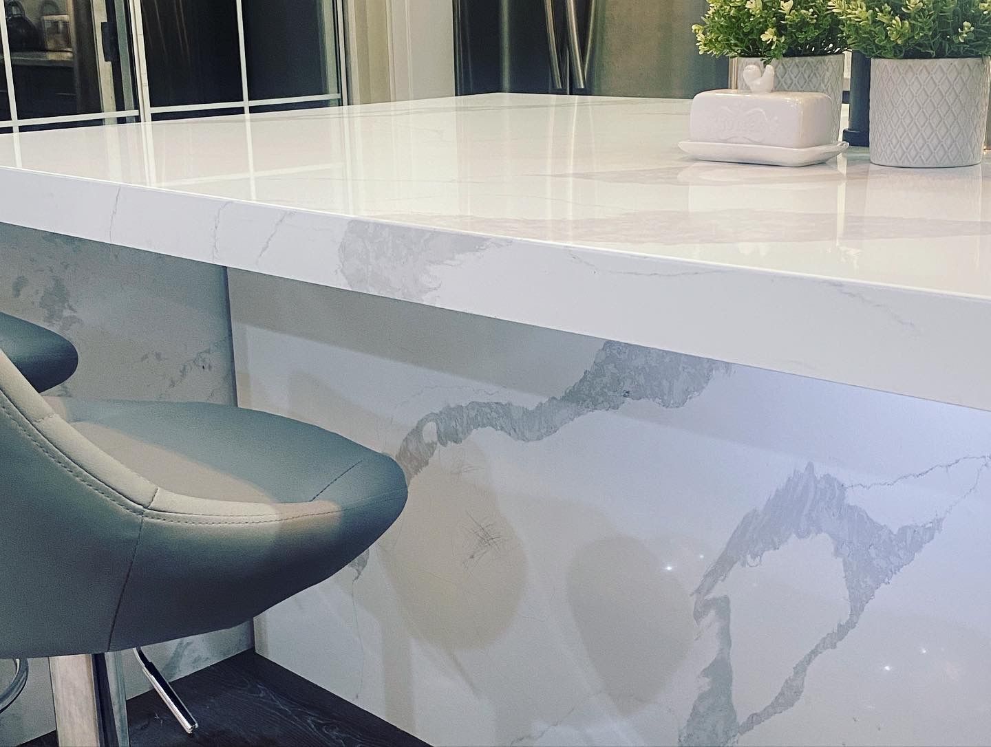 A bar stool is sitting next to a counter in a kitchen.