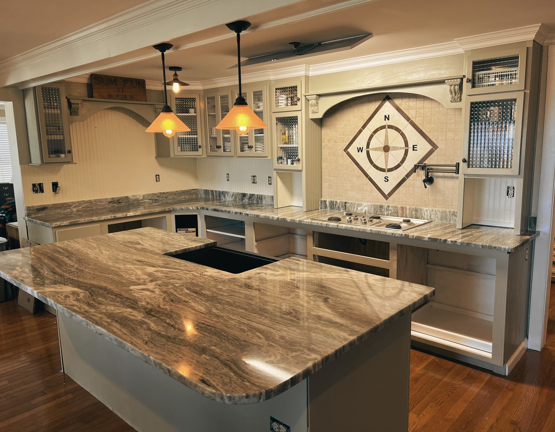 A kitchen with a large island and granite counter tops