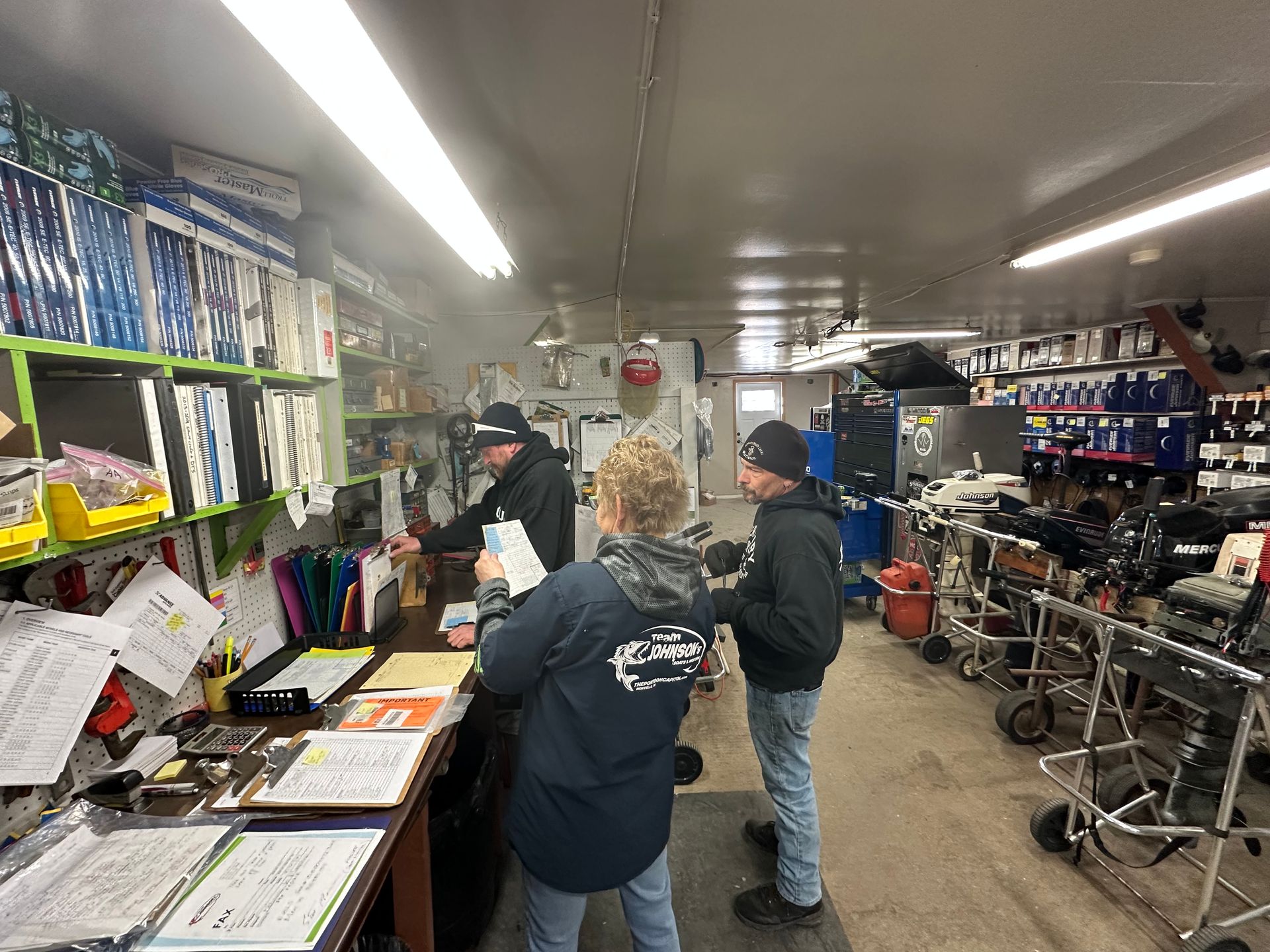 A group of people are standing in a store talking to each other.