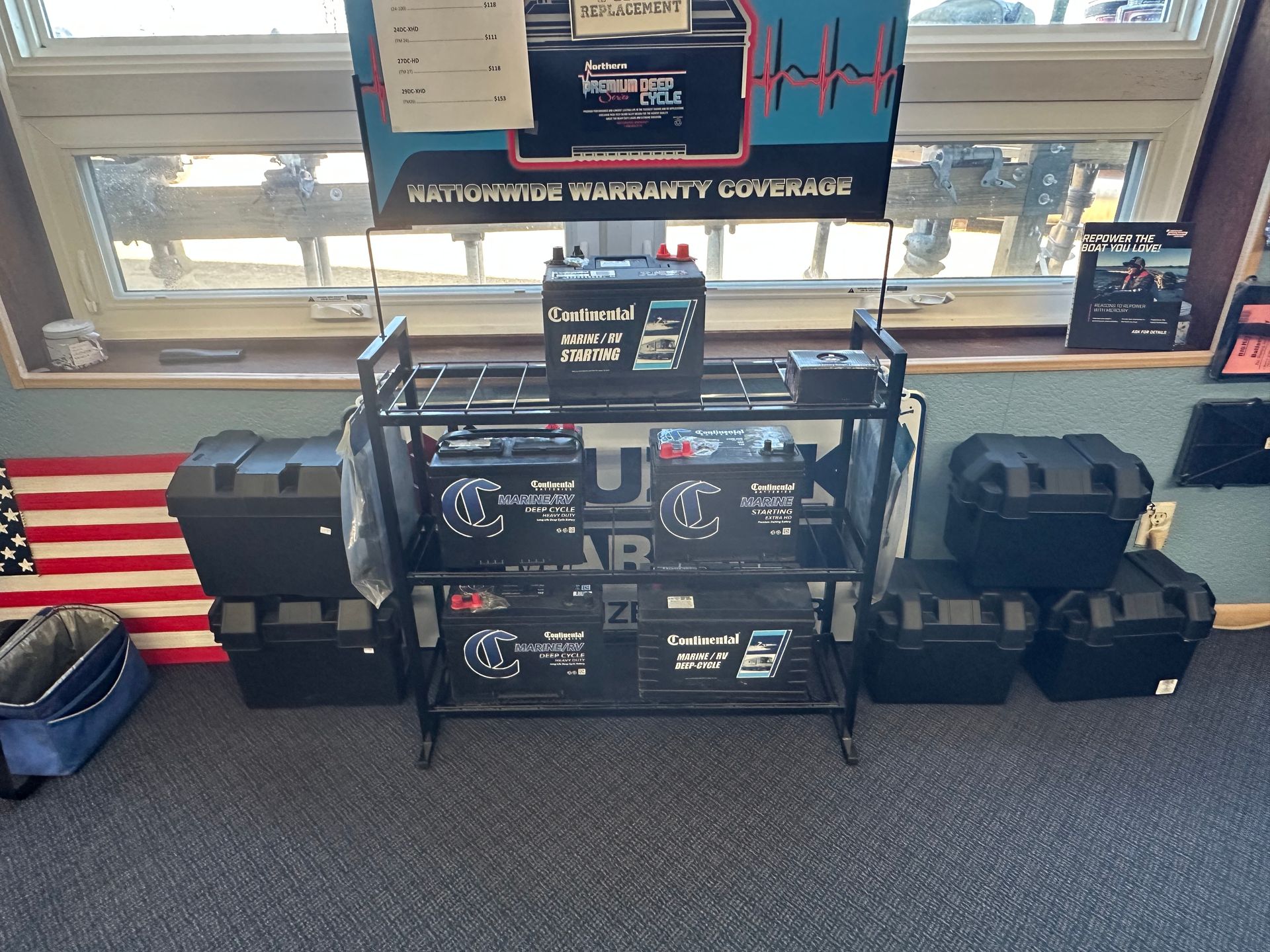 A display of batteries in a store with an american flag in the background