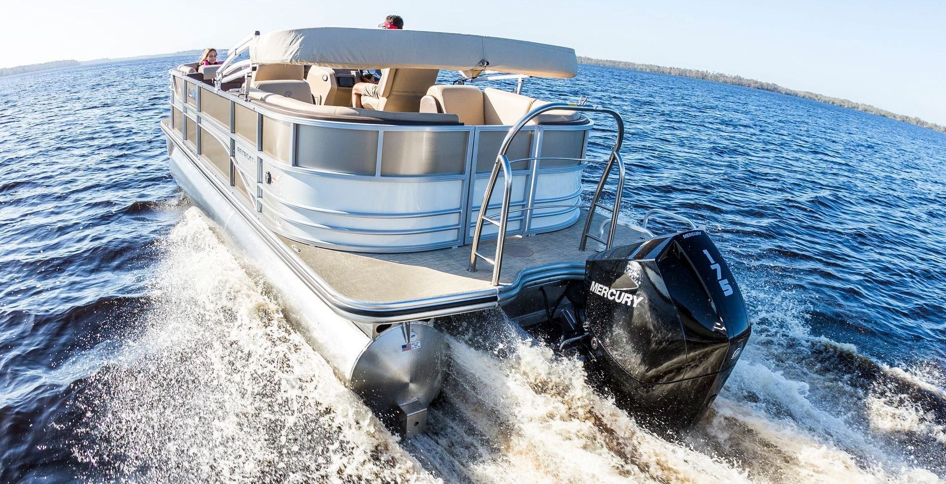 A pontoon boat is floating on top of a body of water.
