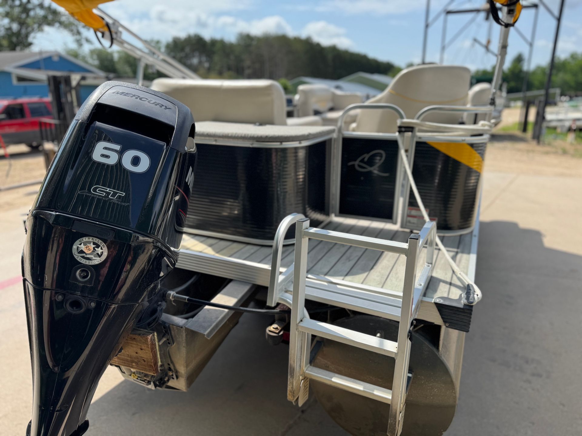 Pontoon boat with black and yellow accents, Mercury 60 engine, and a ladder at the stern.