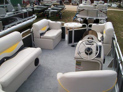 The inside of a pontoon boat with a steering wheel