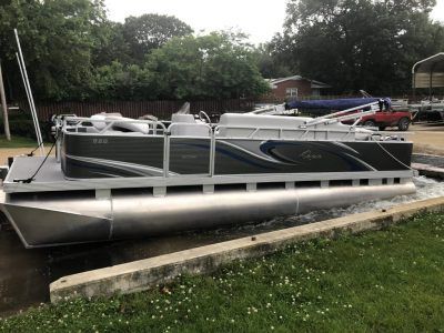 A pontoon boat is docked in a dock next to a body of water.