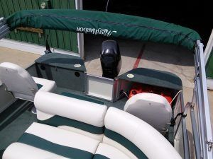 A pontoon boat with a green canopy and white seats