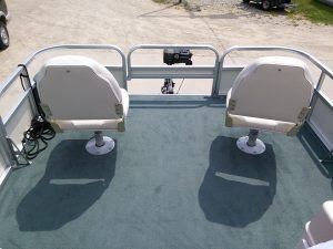 There are two chairs on the back of a pontoon boat.