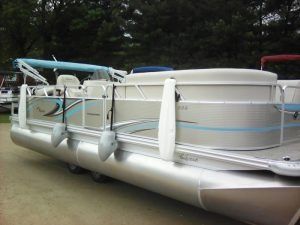 A pontoon boat is parked on the side of the road.
