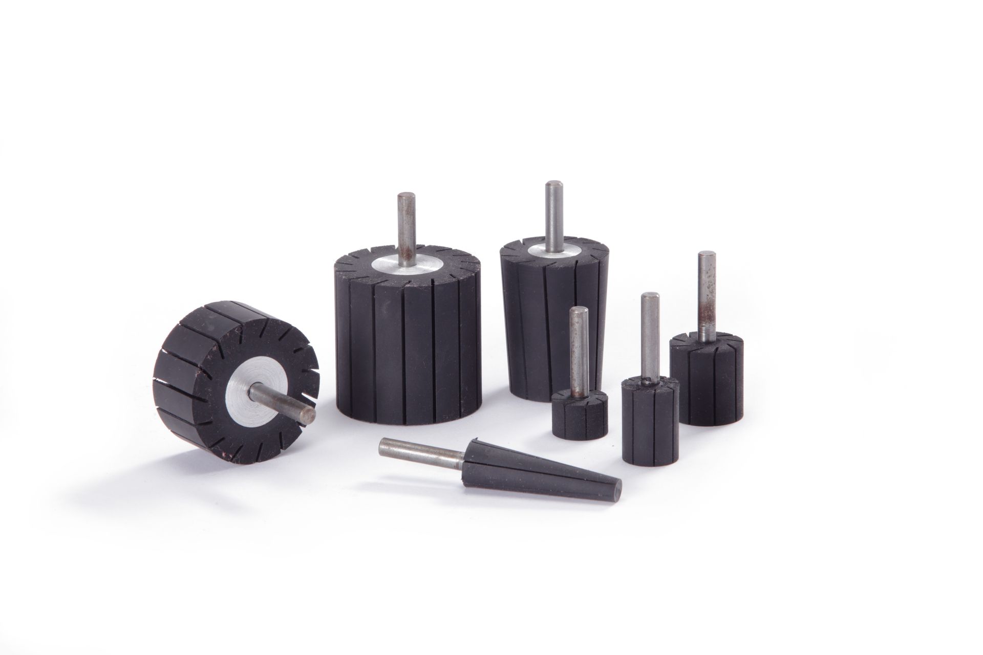 A group of black rubber wheels with metal pins on a white surface.