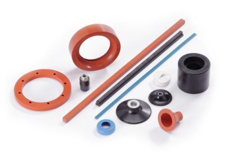 A variety of rubber parts are laying on a white surface.