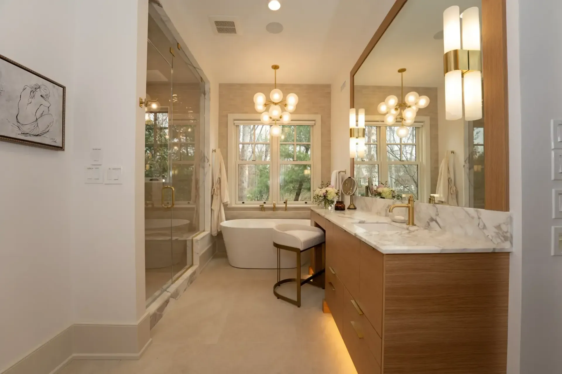 Luxurious bathroom with double vanity, marble countertops, soaking tub, and large window