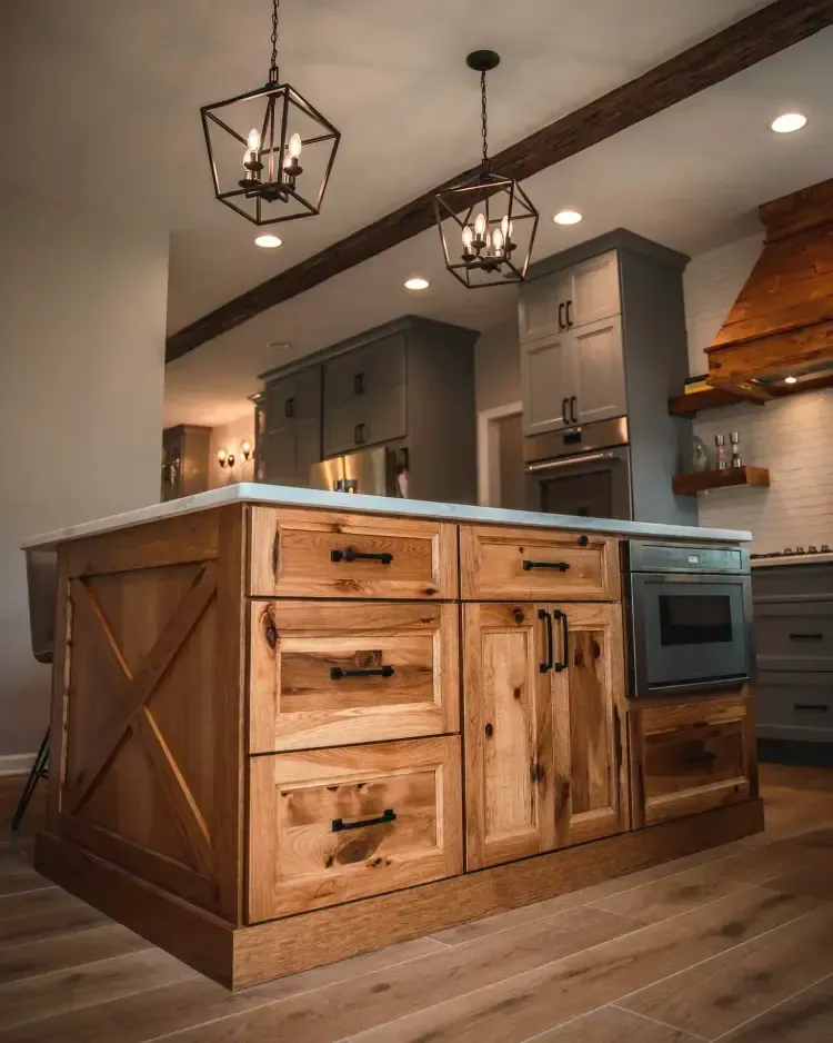 Rustic kitchen island with wood panels, built-in oven, gray cabinets, and hanging lantern lights