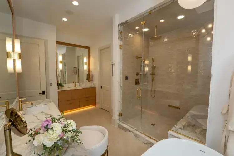 Modern bathroom with glass walk-in shower, double vanity, and white tub with flowers