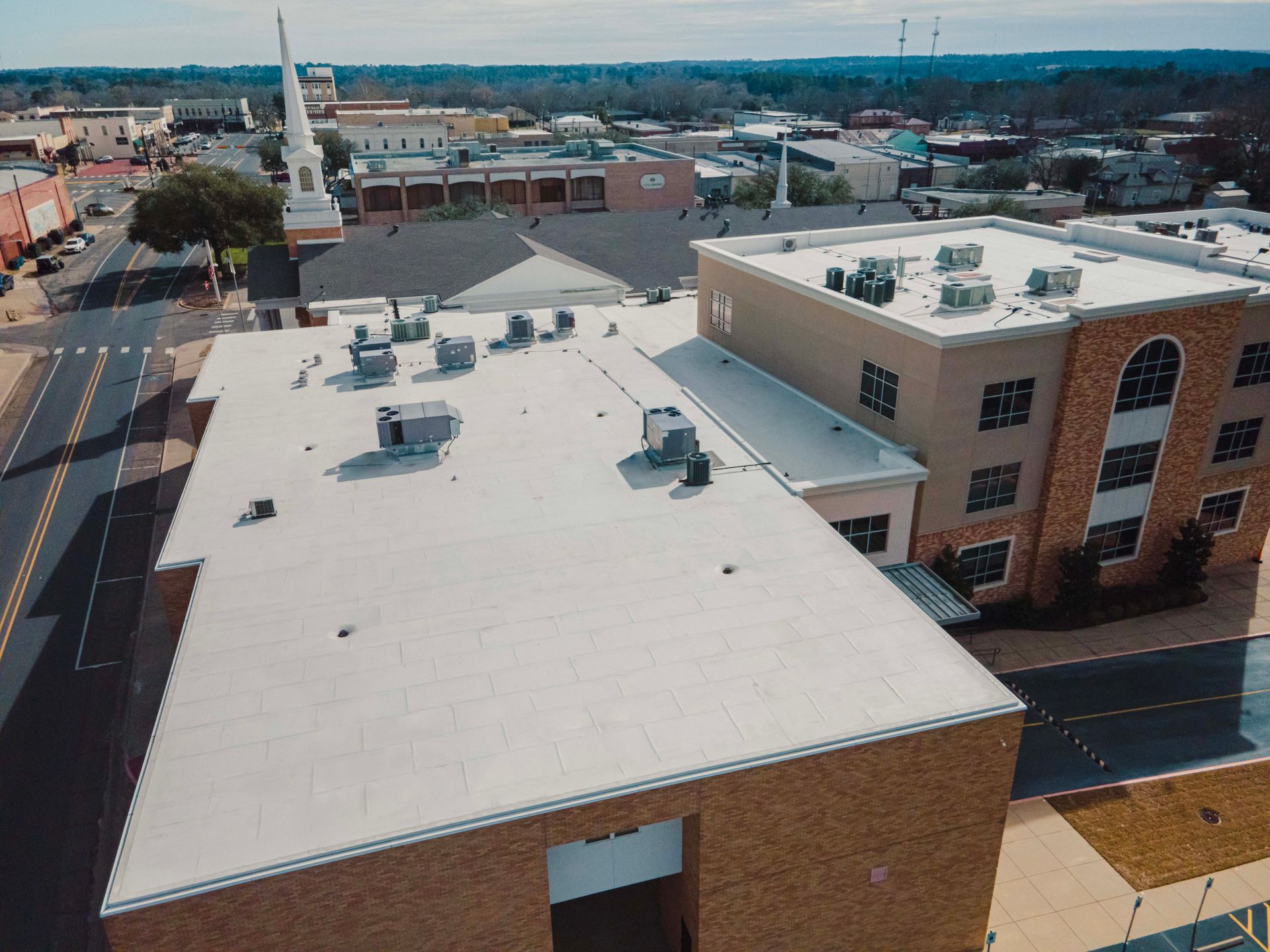 An aerial view of a building with a white roof