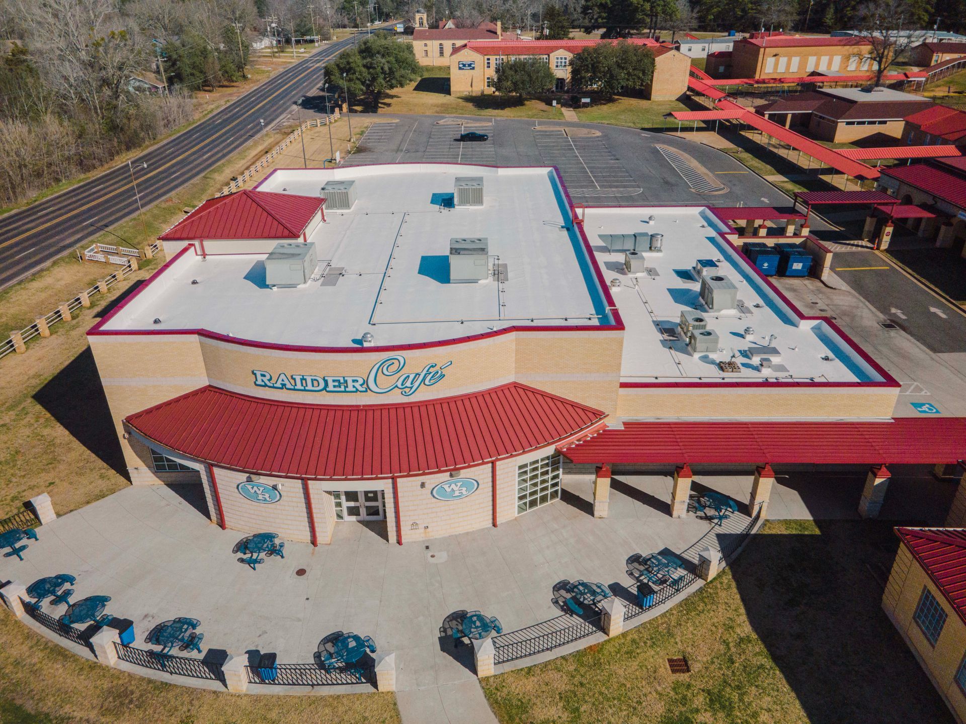 An aerial view of a large building with a red roof