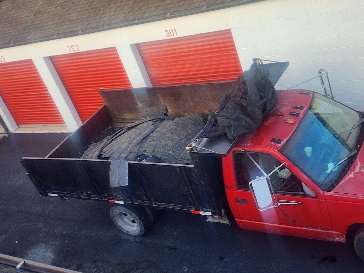 White commercial roof with HVAC units; workers on roof under a blue sky. Billboard in background.