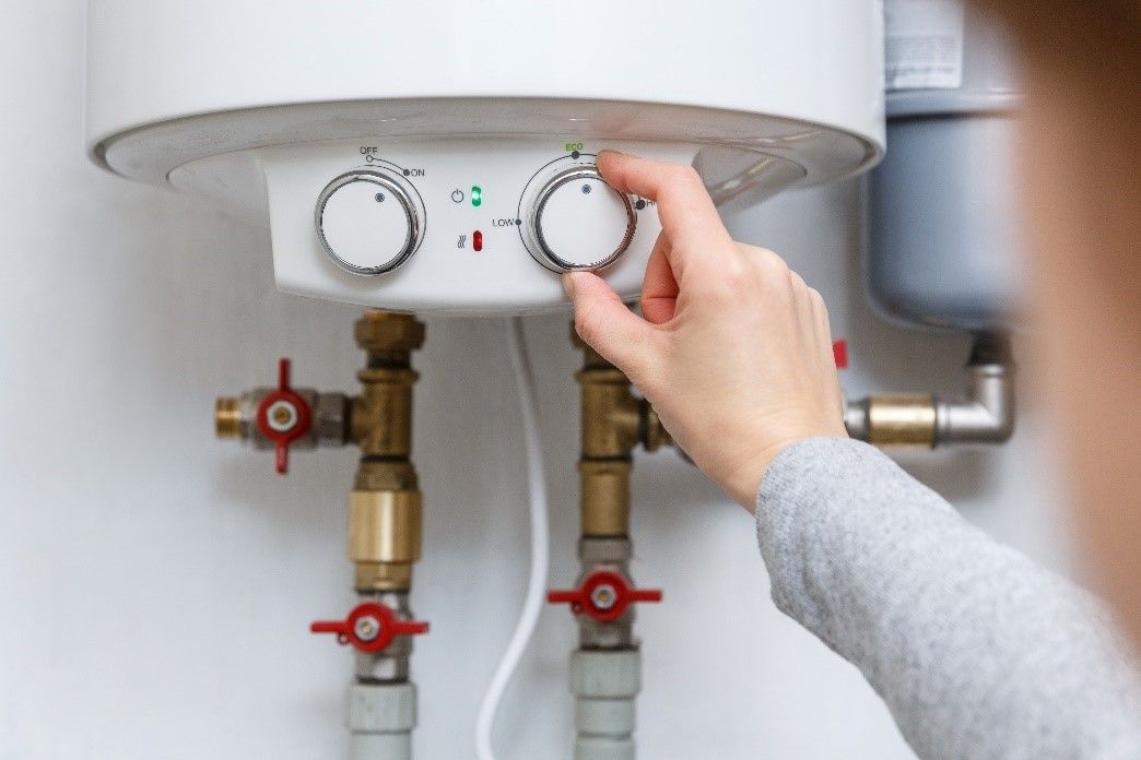 Woman turning on water heater.