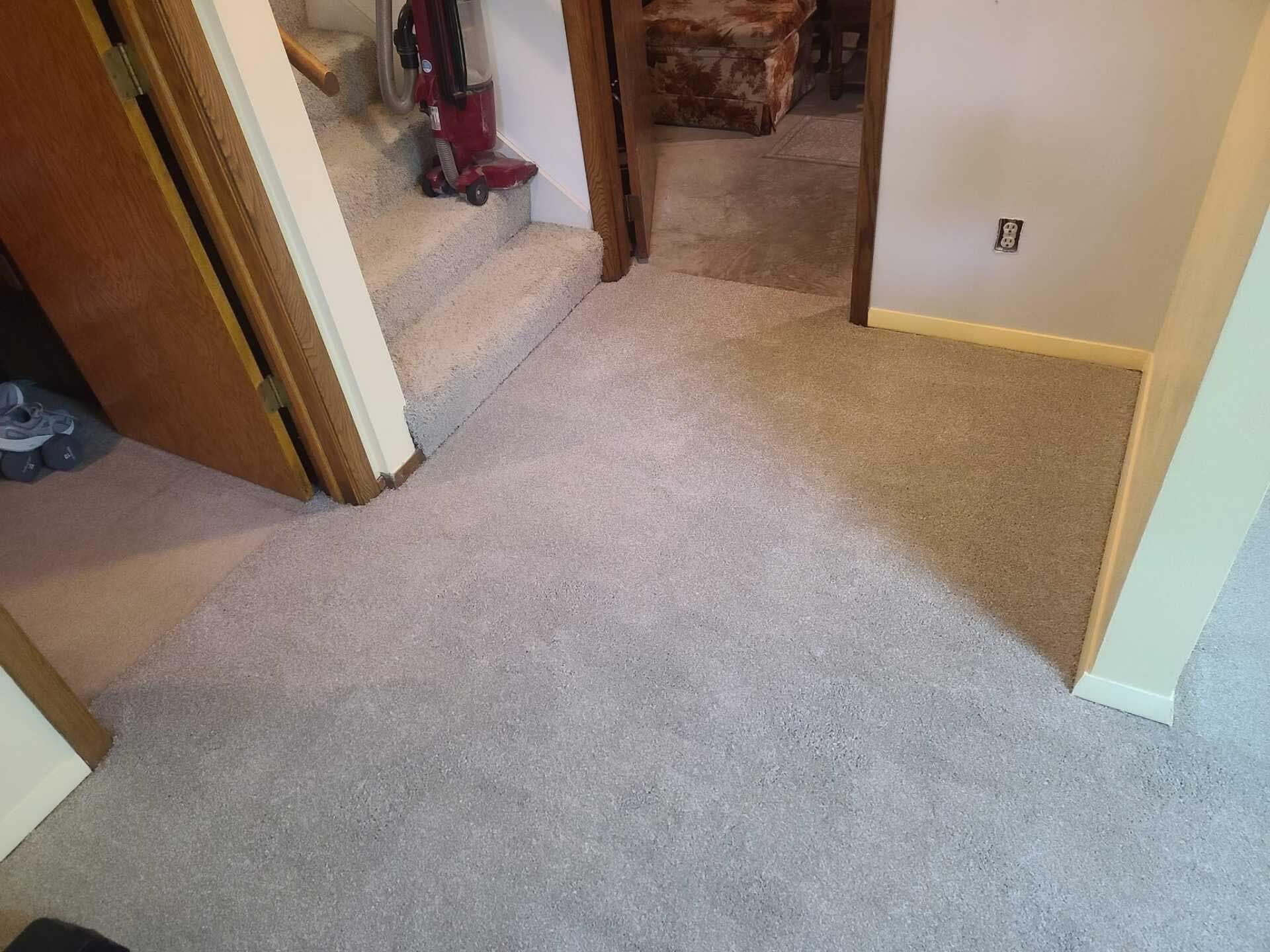 Carpeted room with stairs leading to a doorway, and another doorway on the left.